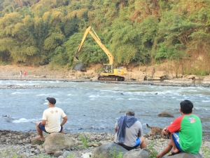 warga memandangi proses penambangan pasir di Kali Progo